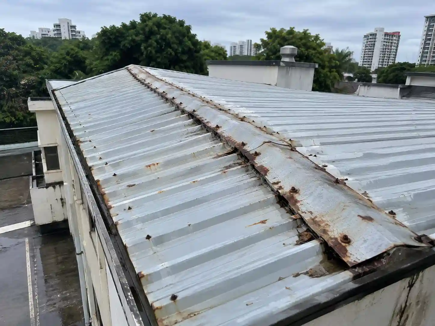 Rusted metal roof seams and deteriorated flashing before repair